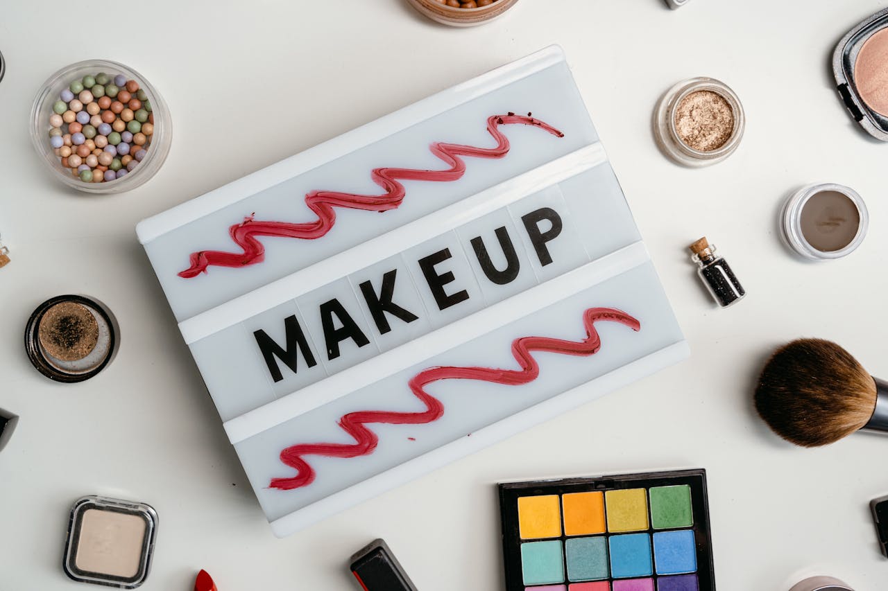 hero-img-01 Flat lay of a colorful makeup palette with various beauty products, emphasizing vibrant cosmetics.